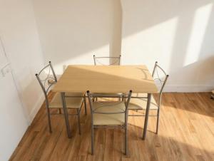 a wooden table and two chairs in a room at Lovely Amour Hyper Centre in Caen