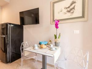 a dining room with a table and a black refrigerator at City Gate - luxury suites in Bari
