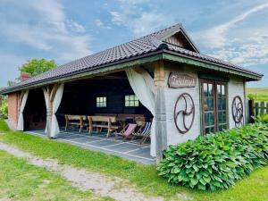 a cottage with a table and chairs on a patio at Agroturystyka Na Górze - Obrocz 116A in Obrocz