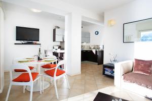 een woonkamer met een tafel en stoelen en een bank bij Laglio Apartment in Laglio