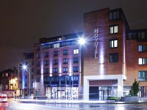 a building with a sign on it at night at Novotel Edinburgh Centre in Edinburgh