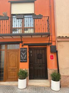 a building with two potted plants in front of a door at El Somni de Paqui Apartamentos Boutique Only Adults in Alfafara