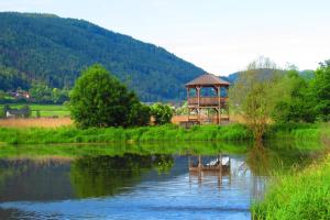 a gazebo sitting on the side of a lake at Pension AdlerHorst in Steindorf am Ossiacher See