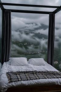 a bed in a room with a large window at Lazord Glass Bungalow Trabzon in Geçit