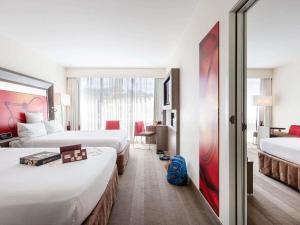 a hotel room with two beds and a blue backpack at Novotel Wellington in Wellington +45 photos