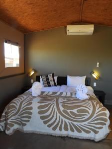 a bedroom with a large bed with towels on it at Soft Adventure Camp in Solitaire