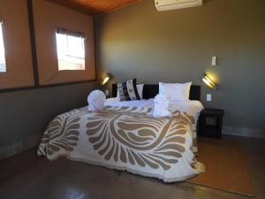 a bedroom with a bed with white and brown sheets at Soft Adventure Camp in Solitaire