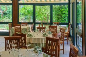 a dining room with tables and chairs and windows at Dimora Relais Excelsa in Gallipoli