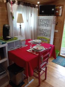 a table with a red table cloth on it at Roulotte Anaîs in Grandcourt