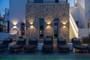 a patio with chairs and lights in front of a building at Kalea Suites in Pollonia +92 photos