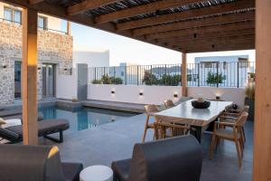 an outdoor patio with a table and chairs and a pool at Kalea Suites in Pollonia