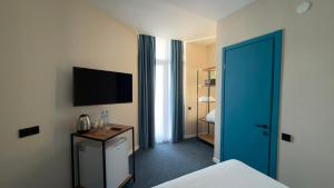 a hotel room with a bed and a television at Pano Hotel in Gonio