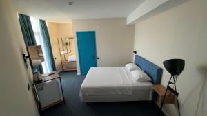 a hotel room with a bed and a blue door at Pano Hotel in Gonio