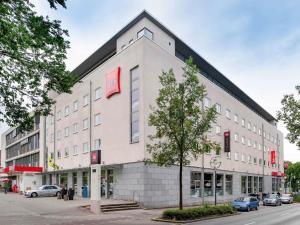 a large white building with a red sign on it at ibis Hotel Dortmund City in Dortmund