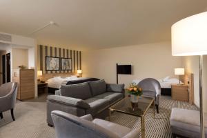 a hotel room with a couch and a bed at Maritim Hotel Königswinter in Königswinter