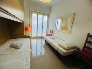 two beds in a room with a mirror and a chair at Suite Excelsior - Bordighera in Bordighera