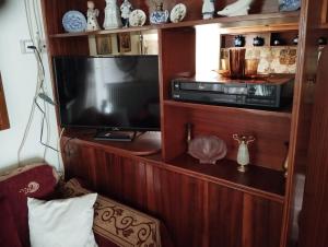 a tv in a wooden cabinet with a television at Fiorela Gest House in Kalabaka