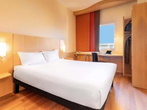 a large white bed in a hotel room at Ibis Madrid Calle Alcalá in Madrid
