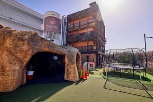 a building with a large tree stump in front of it at Pirates Village in Santa Ponsa