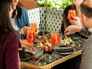 a group of people sitting around a table with wine glasses at Hotel Mercure Roma Corso Trieste in Rome