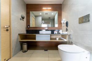 a bathroom with a toilet and a sink and a mirror at Lords CBC Plaza Chitwan in Bharatpur +29 photos