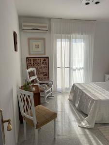 a bedroom with a bed and a chair and windows at Lydia Cabo Cope in Calabardina