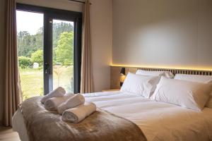 a bedroom with a large bed with towels on it at LA TIERRUCA HOMES in Barcenaciones +42 photos
