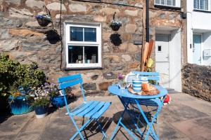 a blue table and two chairs on a patio at Gerallt in Pwllheli