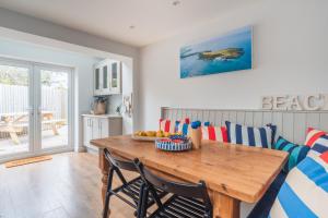 a dining room with a wooden table and chairs at Gerallt in Pwllheli