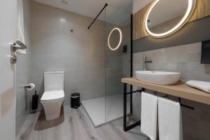 a bathroom with a toilet and a sink and a mirror at Hotel Coral Boutique by gaiarooms in L'Estartit