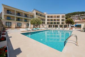 a hotel with a swimming pool in front of a building at Hotel Coral Boutique by gaiarooms in L'Estartit