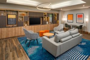 a living room with a couch and chairs and a tv at Four Points by Sheraton Lagos in Lagos