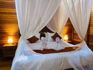 two stuffed animals sitting on top of a bed at Pandawa Villa Sidemen in Karangasem