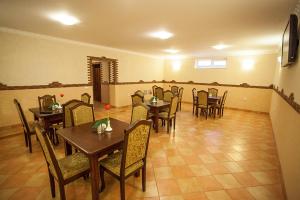 una sala da pranzo con tavoli e sedie in legno di Goldenluxe a Berehove