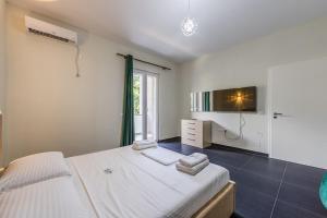 a bedroom with a large bed and a window at Fllad e Valë Luxury Private Pool Villa by PikHost in Tragjas