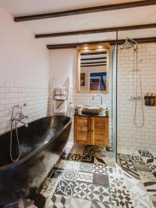 a bathroom with a large tub and a sink at Lulu Guldsmeden in Berlin