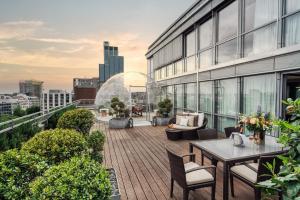 a balcony with tables and chairs on a building at Hotel Kö59 Düsseldorf - Member of Hommage Luxury Hotels Collection in Düsseldorf