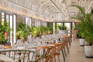 a row of tables and chairs in a room with plants at Bahia Principe Escape Tenerife - Hyatt Inclusive Collection in Adeje