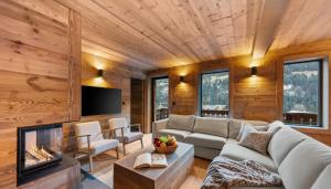 a living room with a couch and a tv at Chalet Dents Blanches - Latitude Champéry in Champéry