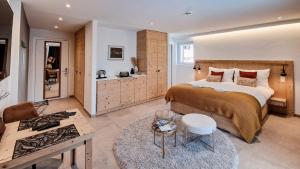 ein Schlafzimmer mit einem großen Bett und einem Tisch in der Unterkunft John's Lodge in Les Collons