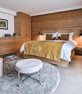 ein Schlafzimmer mit einem großen Bett und einer Holzwand in der Unterkunft John's Lodge in Les Collons