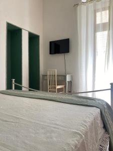ein Schlafzimmer mit Bett, Tisch und Fernseher in der Unterkunft DaLiù in Itri