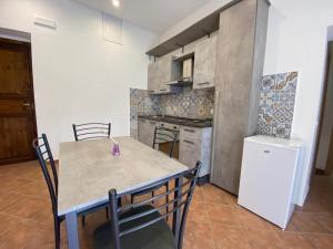 eine Küche mit Tisch, Stühlen und Kühlschrank in der Unterkunft DaLiù in Itri