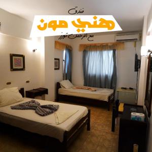 a room with two beds and a sign on the wall at Honeymoon Hotel Marsa matrouh in Marsa Matruh