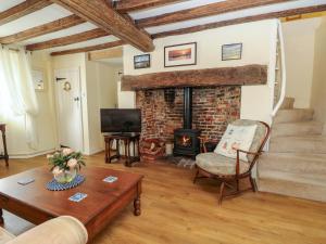 a living room with a brick fireplace and a chair at Tovah in Yarmouth