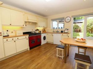 a kitchen with white cabinets and a red stove top oven at Tovah in Yarmouth