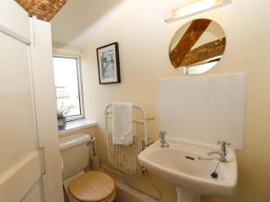 a bathroom with a sink and a toilet and a mirror at Tovah in Yarmouth +30 photos