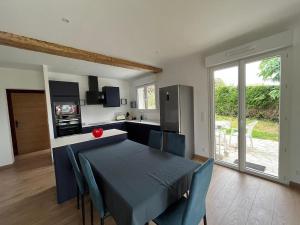 a kitchen and dining room with a blue table and chairs at Bidart, maisonnette sur les Pyrénées in Bidart
