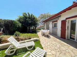 a group of white chairs sitting on a patio at Bidart, maisonnette sur les Pyrénées in Bidart