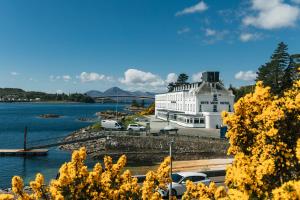 a large white building next to a body of water at The Lochalsh Hotel - Isle of Skye in Kyle of Lochalsh